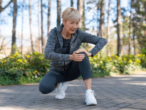 Woman holding knee with joint degeneration