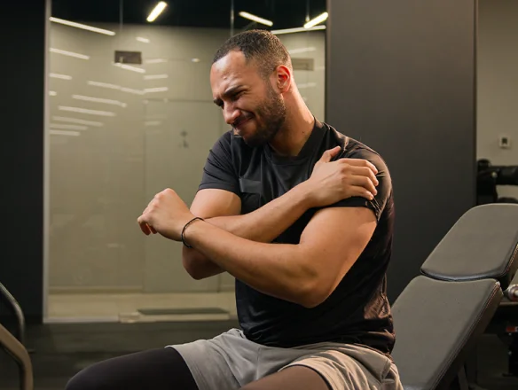 man in gym with AC joint shoulder pain