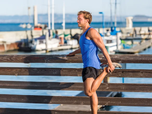 athlete strengthening and stretching knee before a run