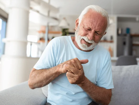 man sitting down with stiff fingers in the morning