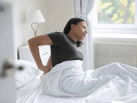 woman with back pain in need of sleep support pillow