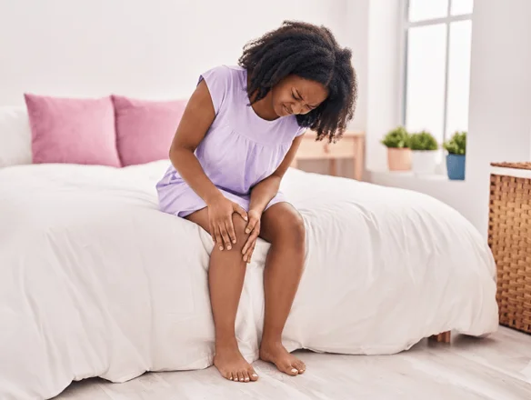 woman getting out of bed with knee pain